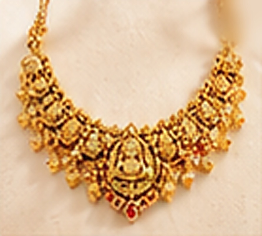 Hand-chased Lakshmi motifs with ruby accents, in 22K gold.
